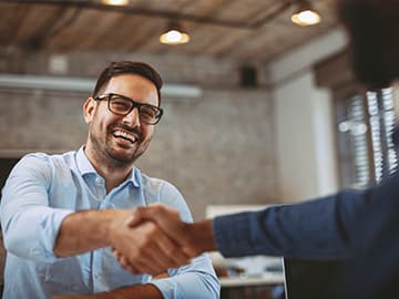 Two people shaking hands and smiling