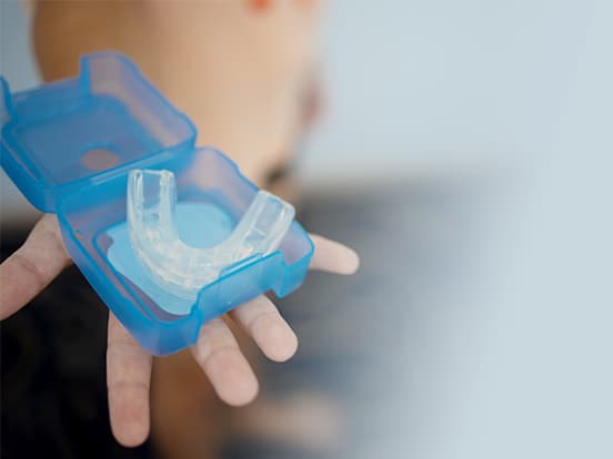 Person holding a mouth guard in their hand