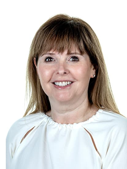 Smiling woman with straight, light brown hair wearing a white blouse
