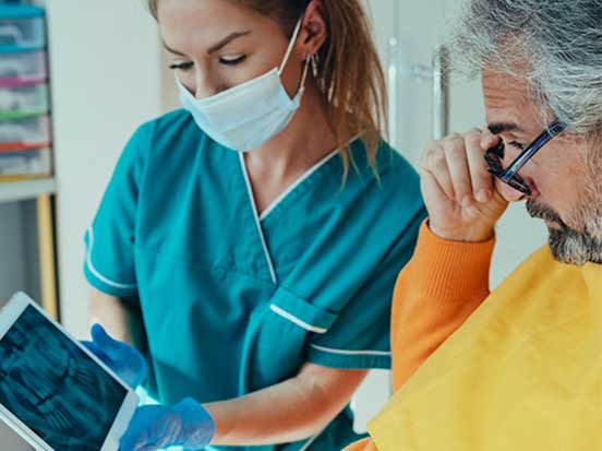 A dentist showing patient x-ray images